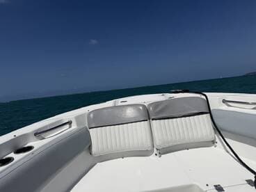 Interior view of a boat's seating area, showcasing comfortable helm seating against a backdrop of turquoise waters — perfect for relaxing while cruising.