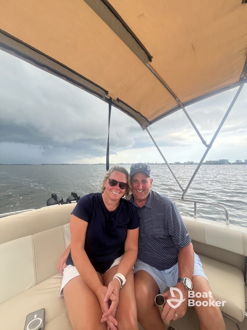 A happy couple enjoys a moment together on a boat, showcasing the perfect setting for a romantic getaway or fun day on the water.