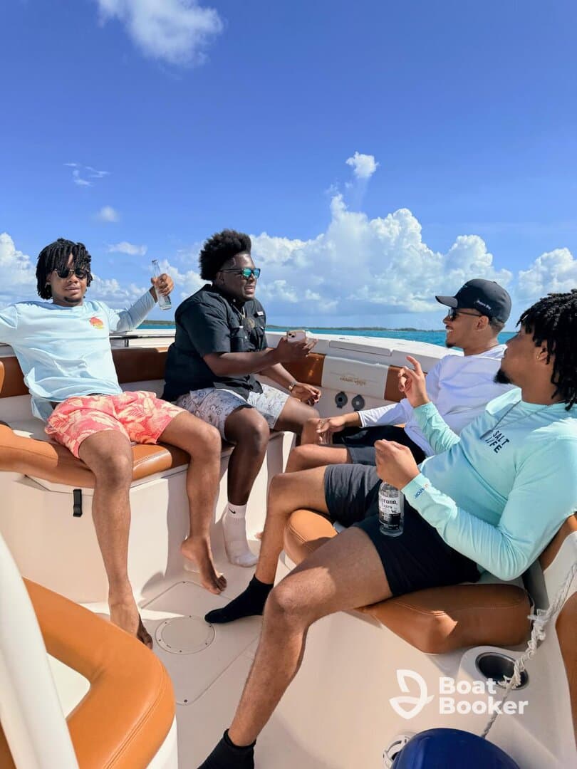 A group of friends enjoys a lively moment aboard a boat, sharing drinks and laughter under a bright blue sky — perfect for a day of fun on the water.