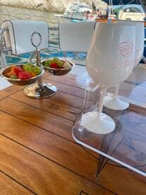 A beautifully arranged snack of fresh fruit and cocktails on a boat table, perfect for enjoying while cruising the waters.