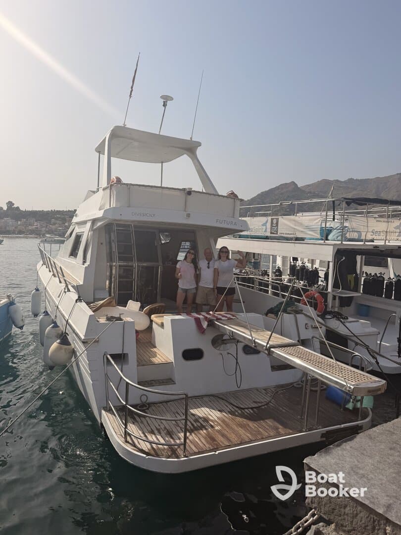 A group of friends poses on the deck of a boat docked at the marina, showcasing a perfect day out on the water.
