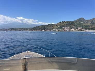 A stunning view from the bow of a boat, showcasing the picturesque coastline and mountains in the background — perfect for exploring scenic destinations.