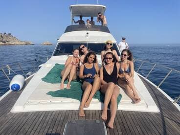 A lively group of friends enjoys a sunny day on a yacht, lounging and soaking up the sun — perfect for summer celebrations and memorable outings on the water.