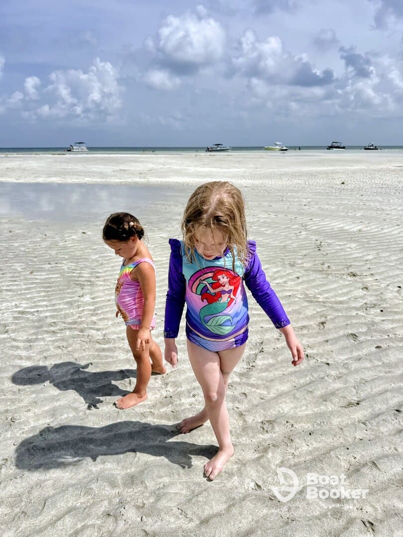 Two children explore the sandy beach, enjoying a fun day in the sun — a perfect family outing by the water.