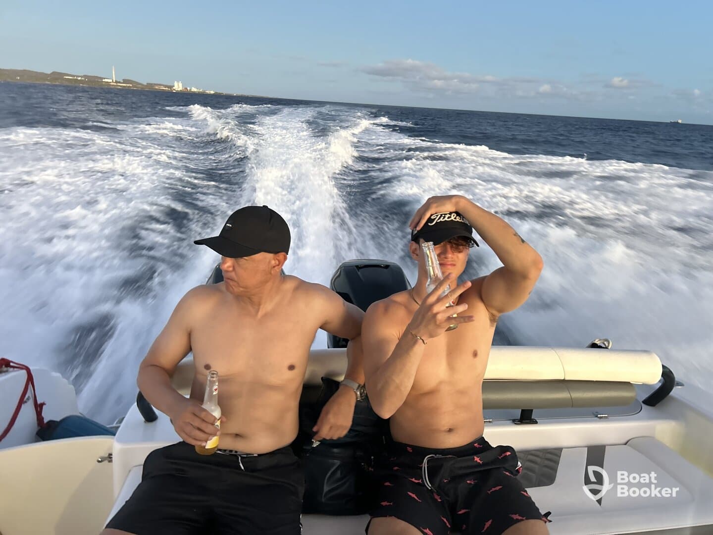 Two friends enjoy a lively boat ride, sipping drinks and soaking up the sun — a perfect moment for a fun day on the water.