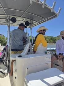 A group of friends enjoys a sunny day on a boat, showcasing camaraderie and fun on the water.