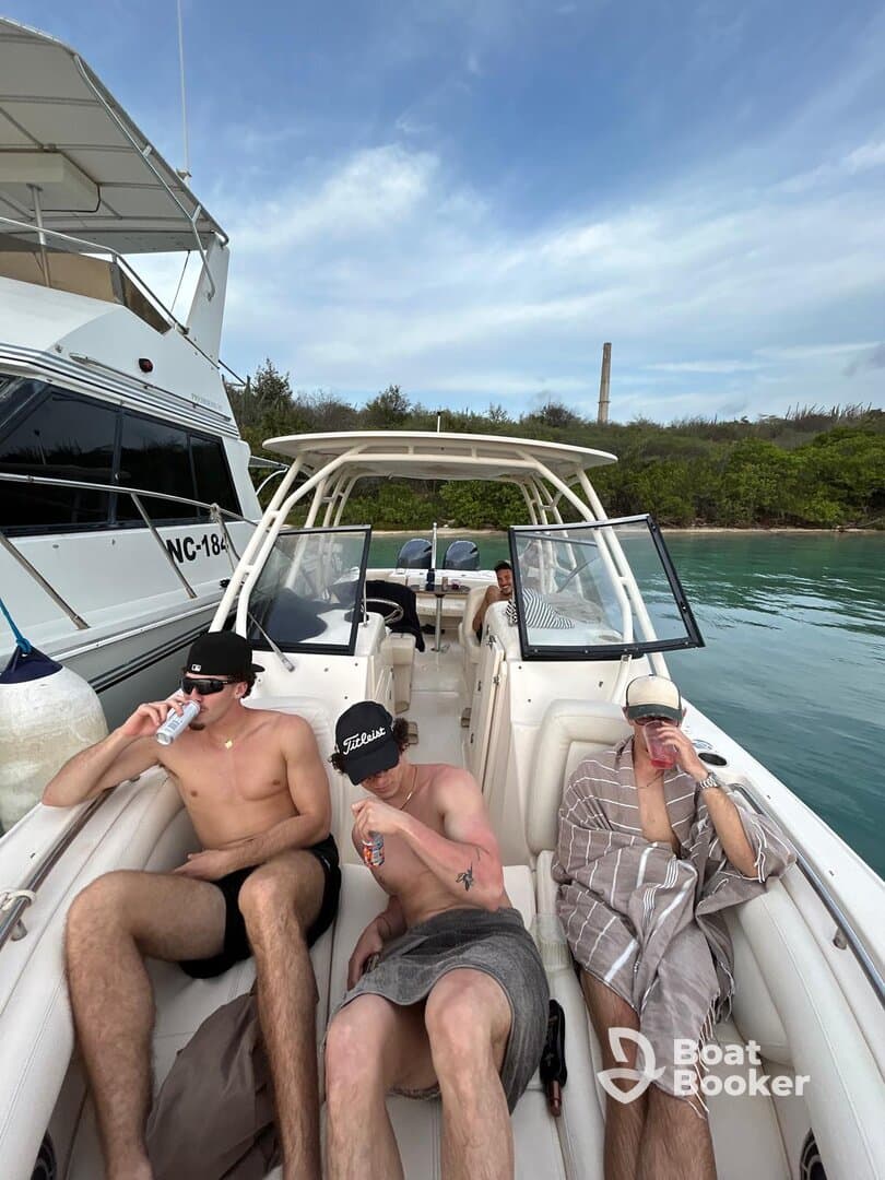 A group of friends relaxes on a boat, enjoying drinks and the sun — perfect for a fun day out on the water.