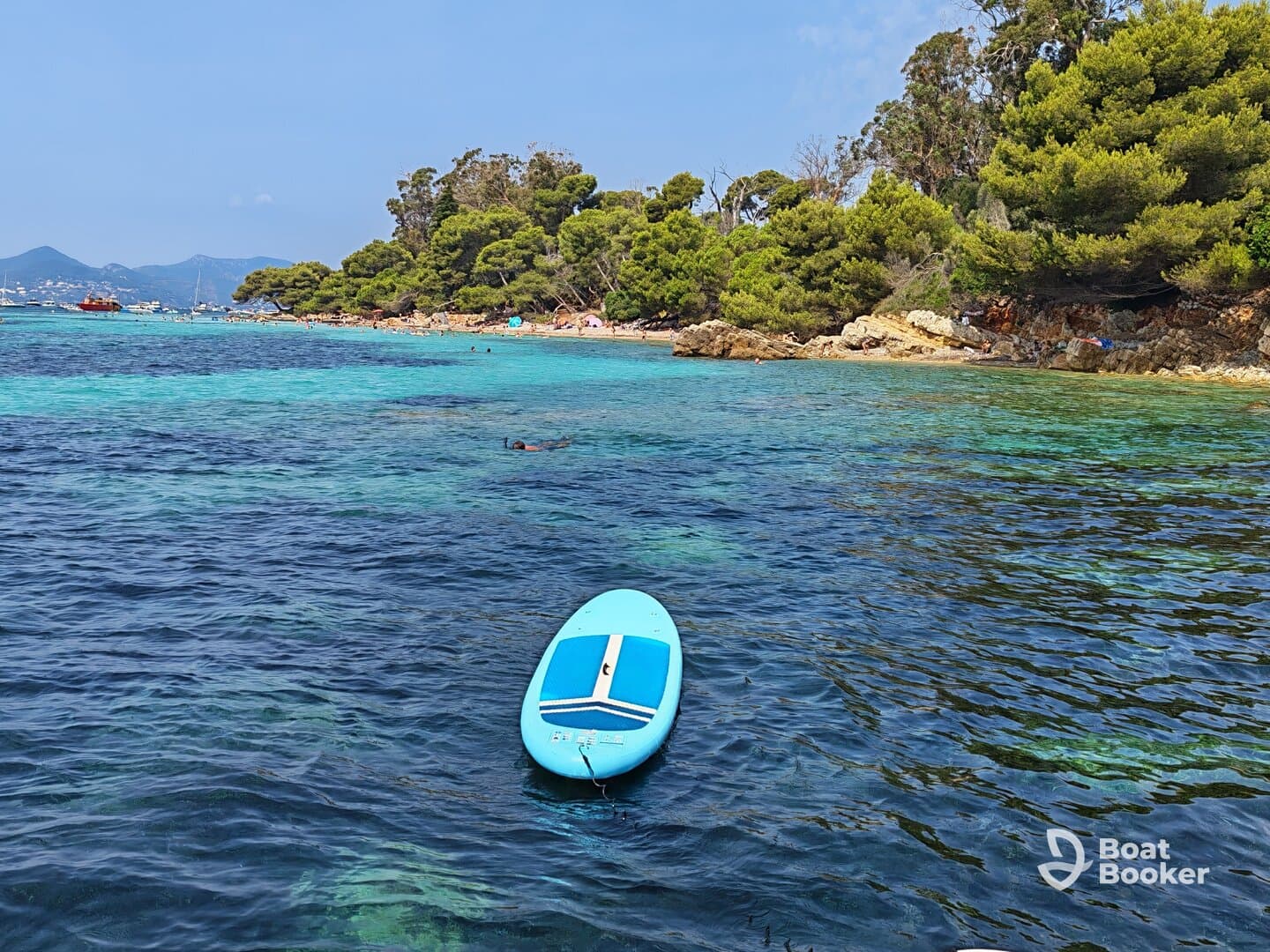 A vibrant scene showcasing a paddleboard in clear waters, with beachgoers enjoying the sun and swimming in the background — perfect for a day of relaxation and adventure.