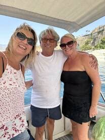 A cheerful group of friends poses for a selfie on a boat, capturing a joyful moment during their maritime adventure.