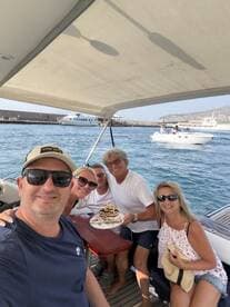 A joyful group celebrates a 25th birthday aboard a boat, complete with a delicious cake and smiles all around — perfect for memorable gatherings on the water.