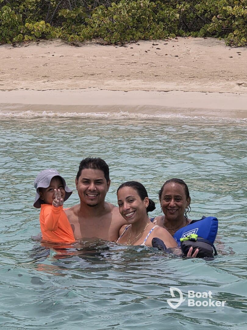 A joyful family enjoys a fun day swimming in clear waters, creating lasting memories at the beach.