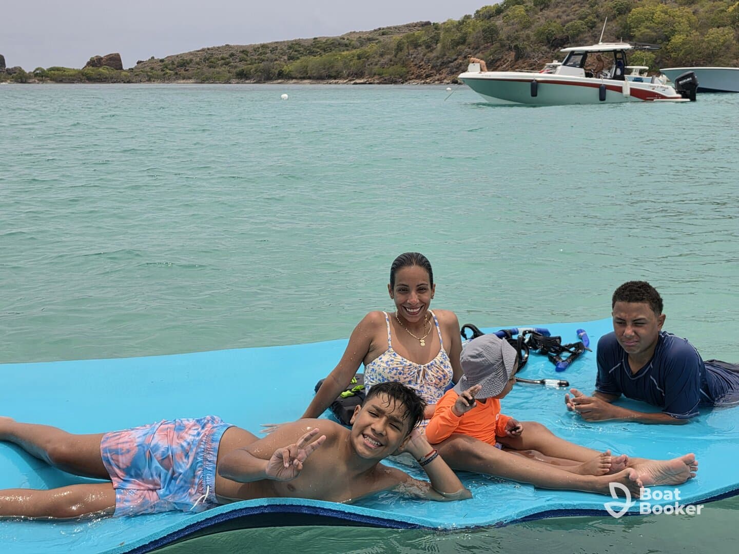 A joyful family enjoys a fun day in the water, relaxing on a floating mat while snorkeling gear is nearby — perfect for memorable aquatic adventures.