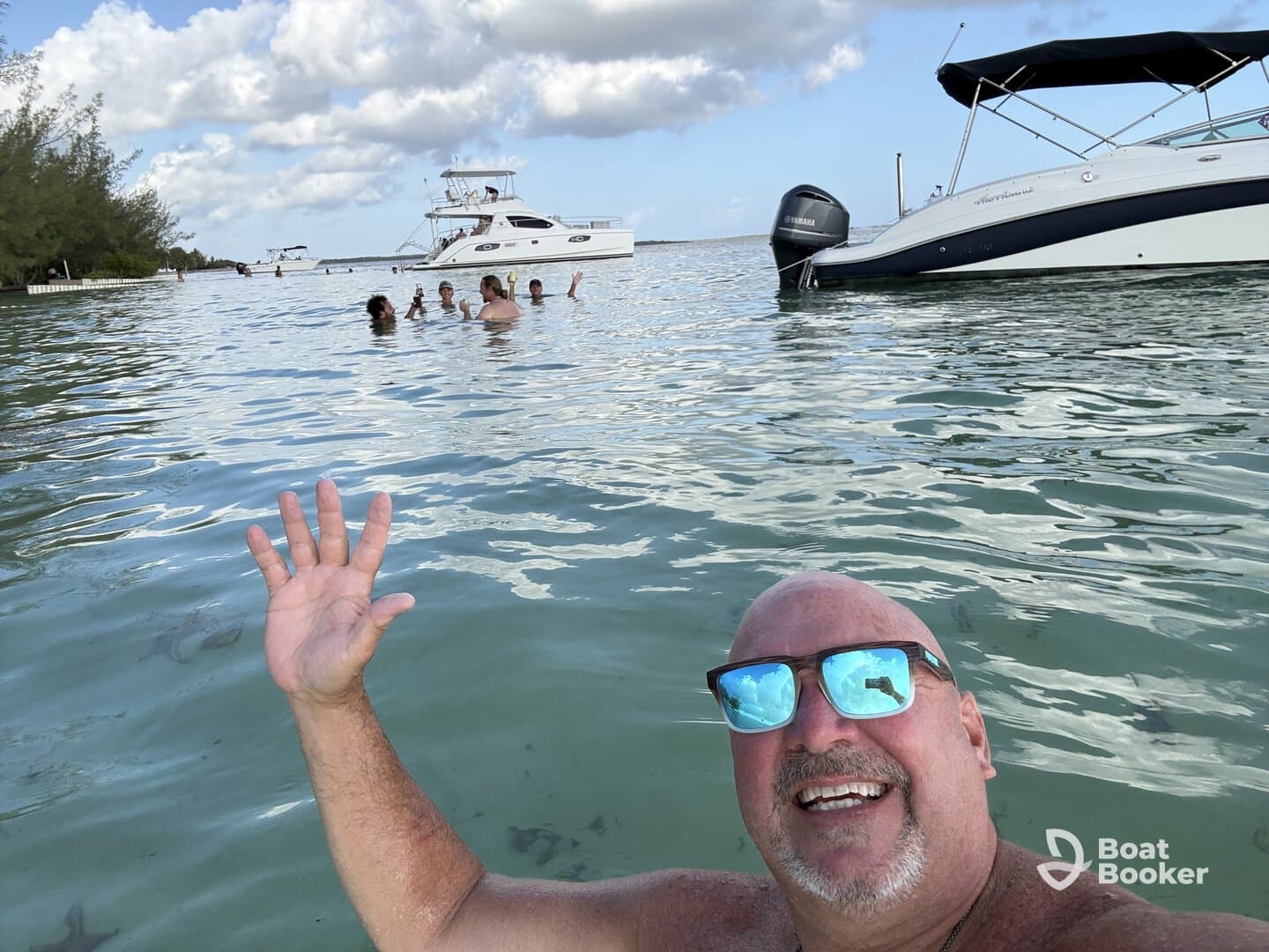 A joyful group enjoys a fun day swimming in clear waters, with boats anchored nearby — perfect for a memorable day on the water.