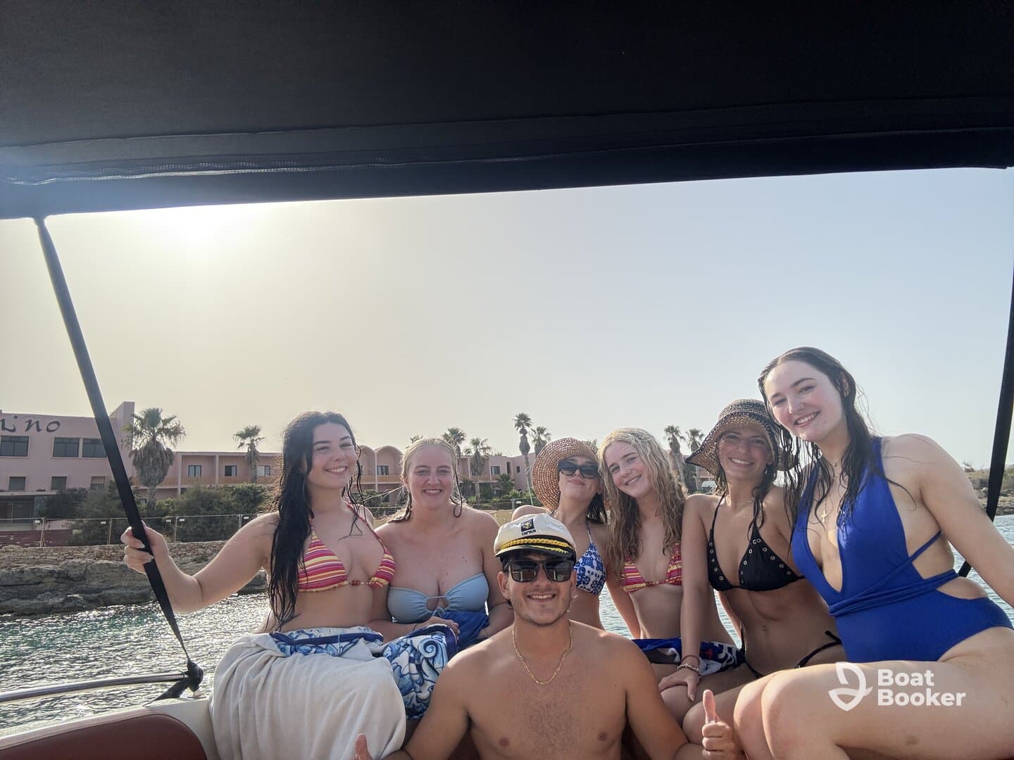 A lively group of friends enjoys a fun day on the water, showcasing camaraderie and celebration aboard a boat — perfect for summer adventures.