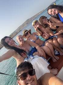 A fun group of friends enjoys a sunny day on the boat, capturing memories with smiles and playful poses — perfect for summer adventures on the water.