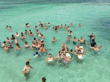 A lively group enjoys a fun day swimming in crystal-clear waters, perfect for celebrations and group outings.