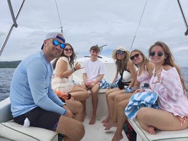 A cheerful group of friends enjoys a day on the boat, showcasing the perfect atmosphere for fun and relaxation on the water.