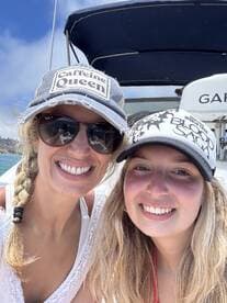 A joyful moment captured with two friends smiling on a boat, showcasing the fun and camaraderie of a day on the water.