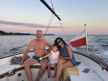 A joyful family enjoys a sunset cruise on a boat, capturing precious moments together with the serene waters as their backdrop.