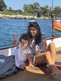 A joyful moment captured on a boat, featuring a mother and her young daughter enjoying their time together by the ocean, perfect for family outings and adventures.
