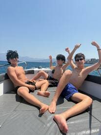 A group of boys enjoys a sunny day on a boat, showcasing the fun and excitement of summer adventures on the water.