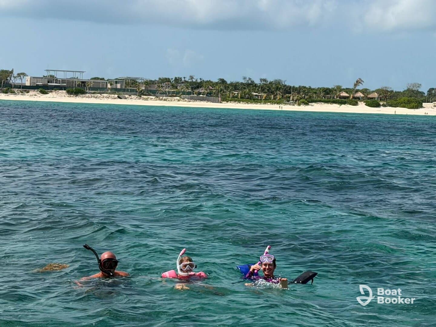 A family enjoys snorkeling in crystal-clear waters, surrounded by a beautiful beach backdrop — perfect for aquatic adventures and family bonding.