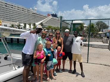 A joyful group of family and friends poses by their boat, ready for a fun-filled day on the water — perfect for family vacations and adventures.