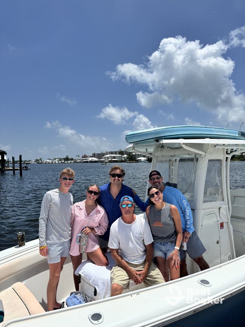 A cheerful group poses for a photo aboard their boat, capturing a fun day on the water with friends and family.
