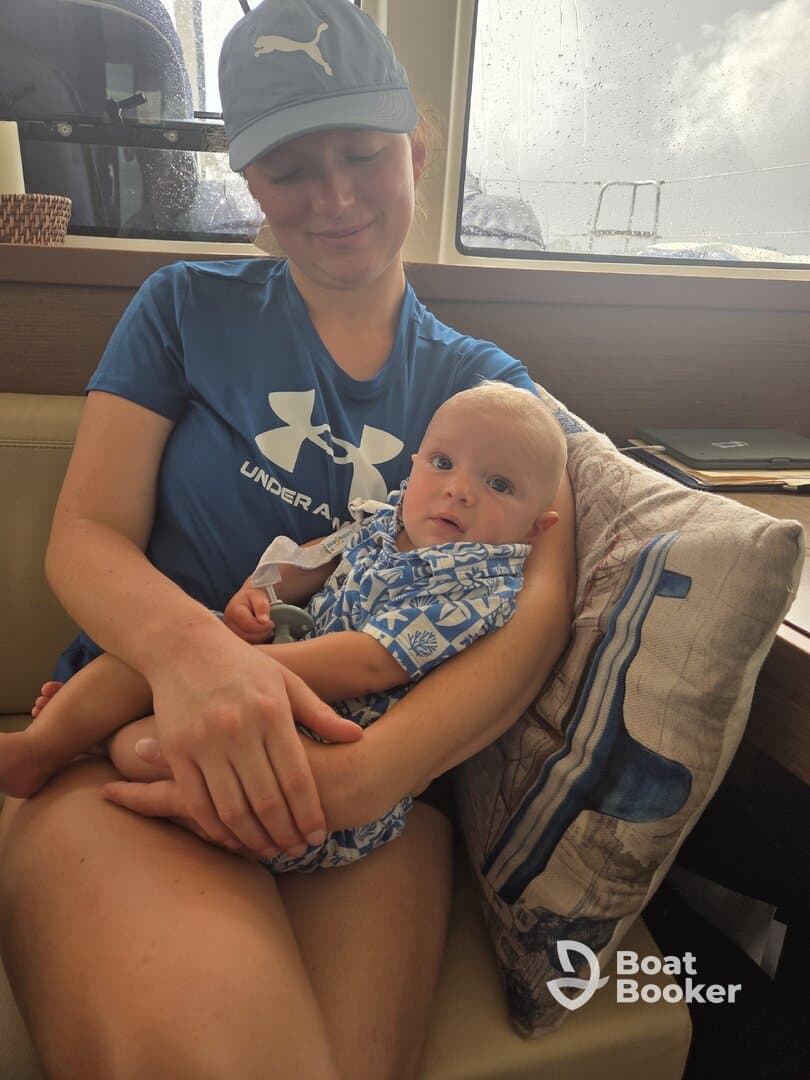 A mother holds her baby in the cozy cabin of a boat, showcasing a warm and intimate moment in a marine setting.