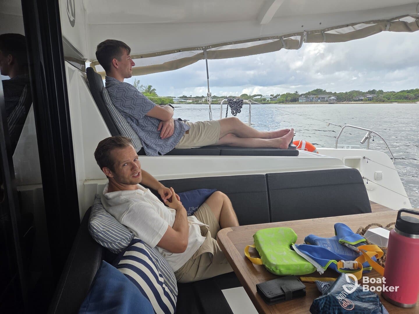 Two guests relax in the comfortable seating area of a boat, enjoying the serene view of the water. Perfect for unwinding during a day on the water.