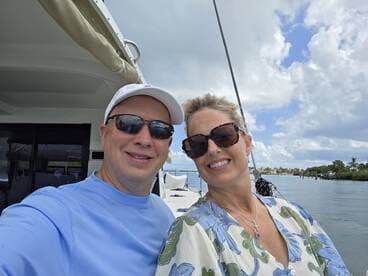 A cheerful couple takes a selfie on a boat, enjoying a beautiful day on the water — perfect for romantic outings or memorable adventures.