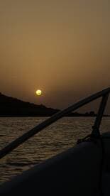 A serene sunset view from the deck of a boat, capturing the tranquil beauty of the evening sky and water, perfect for romantic cruises or peaceful getaways.