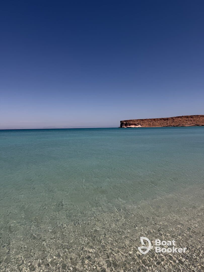 A serene view of clear waters and a rocky coastline, perfect for showcasing the beauty of nature.