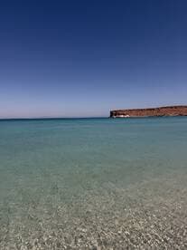 A serene view of clear waters and a rocky coastline, perfect for showcasing the beauty of nature.
