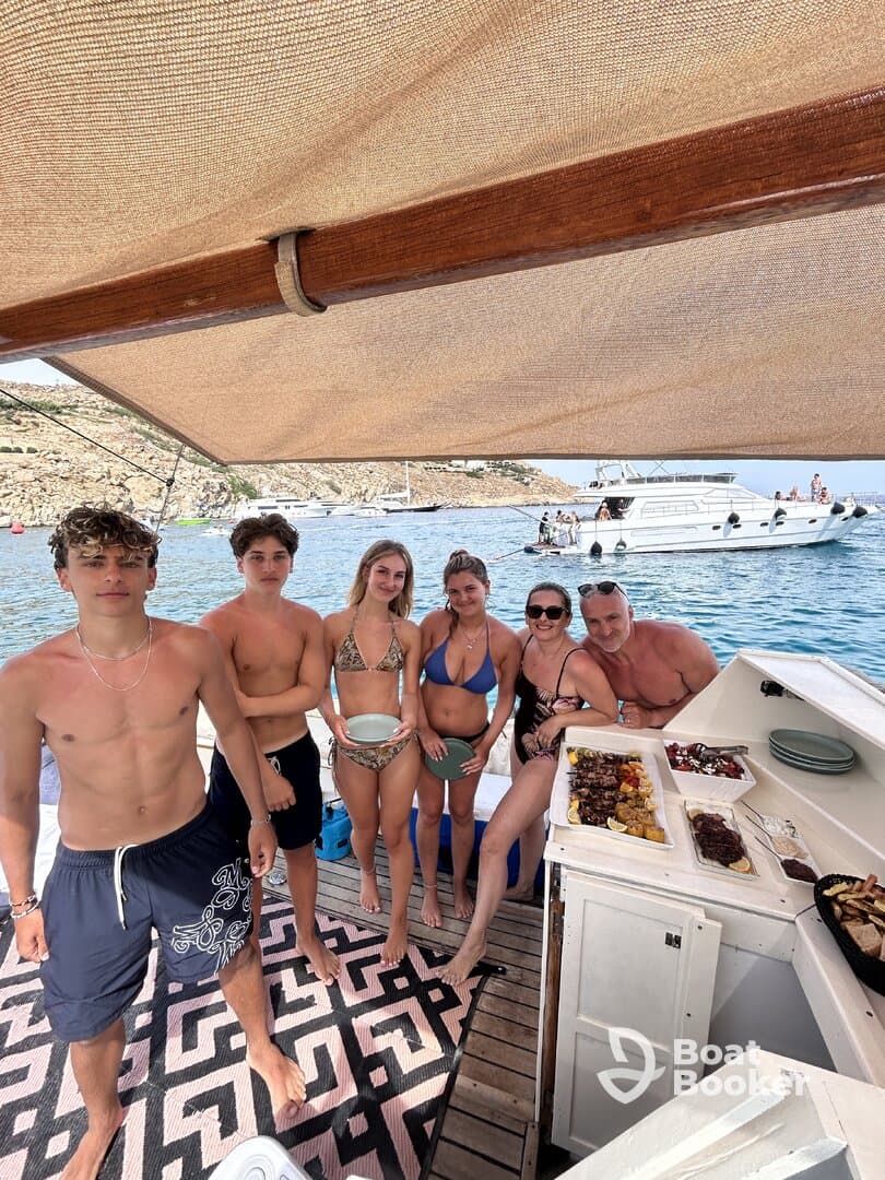 A lively group enjoys a fun day on the boat, showcasing delicious food and a festive atmosphere — perfect for summer celebrations on the water.