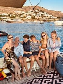 A joyful group of friends and family relaxes on a boat, enjoying the beautiful scenery and each other's company — perfect for memorable summer outings.