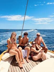A cheerful group enjoys a sunny day on a boat, capturing the essence of family fun and adventure on the water.