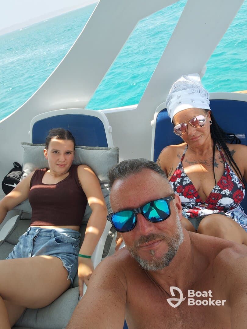 A family enjoys a relaxing moment on a boat, capturing the essence of a perfect day on the water with stunning turquoise views.