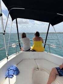 Two friends relax on the deck of a boat, enjoying the scenic views and the open water — a perfect moment for camaraderie and adventure.