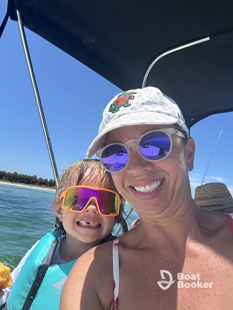 A joyful moment captured on a boat with a smiling mother and child, showcasing a fun day on the water under the sun.