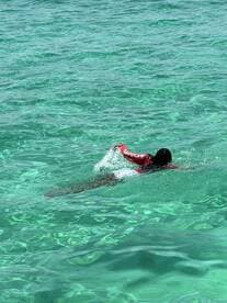 A person enjoys swimming in crystal-clear waters, showcasing the beauty of aquatic adventures — perfect for snorkeling and exploring marine life.