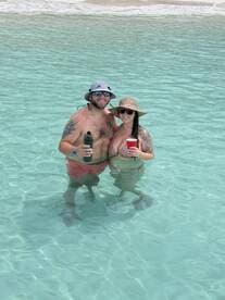 A couple enjoys a refreshing moment in the shallow turquoise waters, perfect for beach celebrations and romantic getaways.