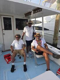 A group of friends relaxes on the deck of a boat, enjoying their time together in a scenic setting. Perfect for capturing moments of camaraderie on the water.