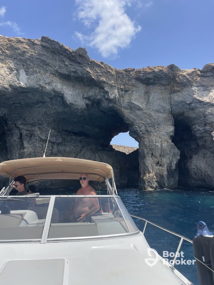 Guests enjoy a scenic boat ride near a stunning rock formation, capturing the essence of adventure on the water.