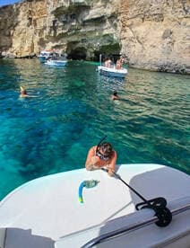 A vibrant scene of snorkelers enjoying the crystal-clear waters near a stunning cave, with boats and fellow adventurers adding to the excitement of this unforgettable aquatic experience.