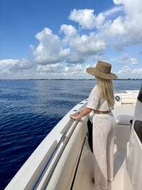 A woman enjoys the serene ocean view from the deck of a boat, embodying the perfect moment of relaxation on the water.