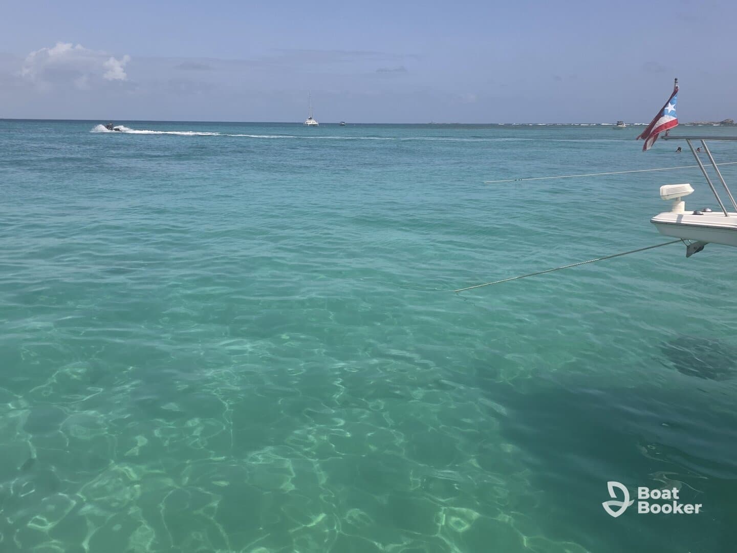 A serene view of a boat anchored in crystal-clear waters, showcasing the vibrant turquoise hues of the ocean — perfect for a relaxing day on the water.