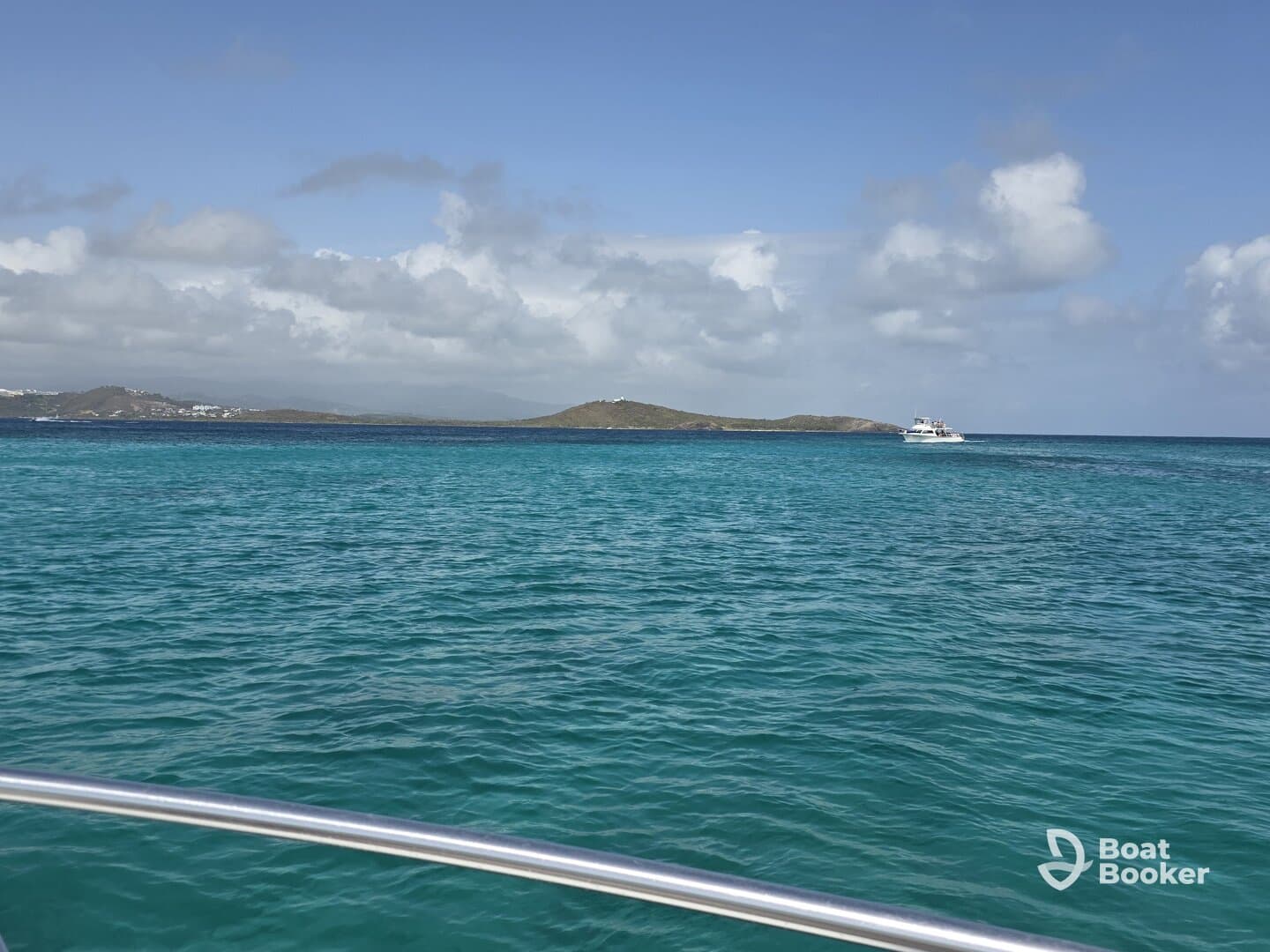 A stunning view of turquoise waters and a distant boat against a picturesque coastline, perfect for showcasing the beauty of a boating adventure.