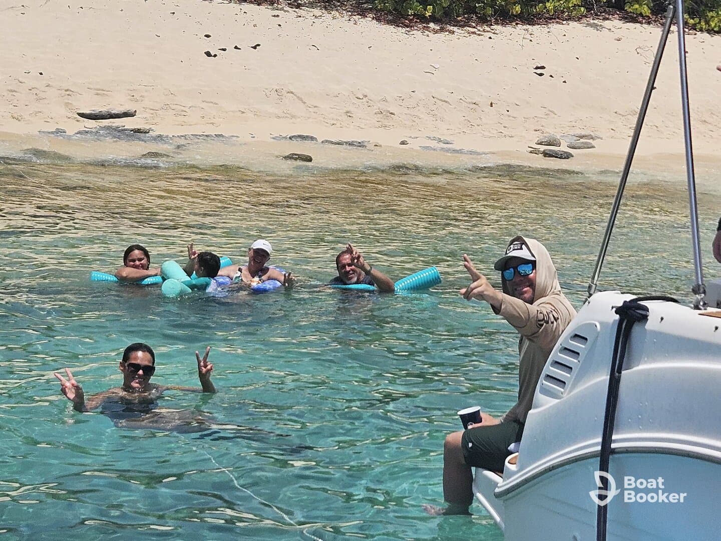 A lively group enjoys a refreshing swim in crystal-clear waters, showcasing the perfect beach day filled with fun and relaxation.