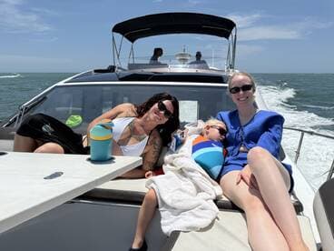 A family enjoys a sunny day on the boat, relaxing together with drinks and laughter — perfect for creating lasting memories on the water.